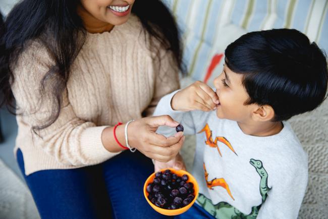 Mom and boy eating frozen blueberries